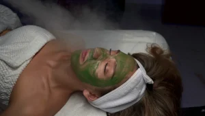 Client receiving a green facial mask and steam treatment at Parie Med Spa