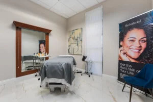 Hydrafacial treatment room with equipment and promotional banner at Parie Med Spa