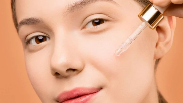Model applying a serum with a dropper to her cheek